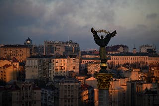 This photo taken on 24 January 2025 shows the Independence Monument towers over Esteghlal Square, while buildings in the background are illuminated by a ray of sunlight during sunrise in Kyiv.